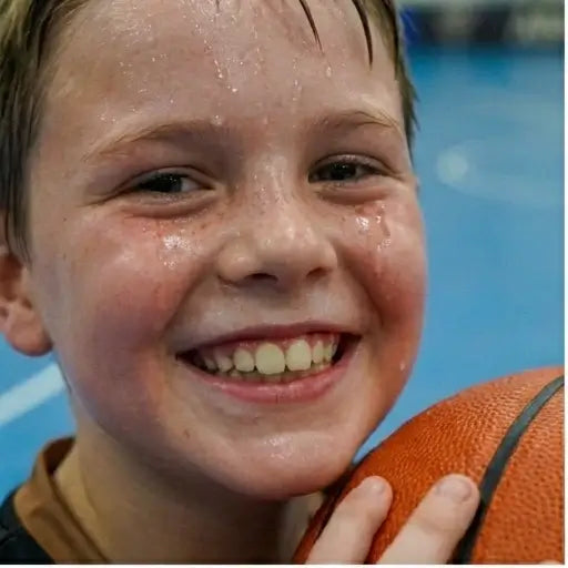 A 9-year-old boy demonstrating improved shooting form under the guidance of an elite coach at Box Hill South basketball academy.