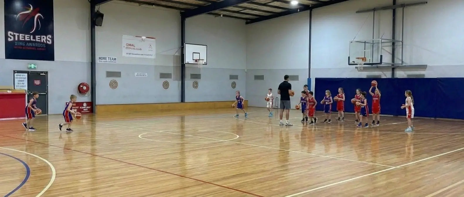 Junior basketball athletes training under elite coaching at First Pick Academy’s Donvale campus, featuring professional indoor courts and scientific movement drills for ages 5-12.