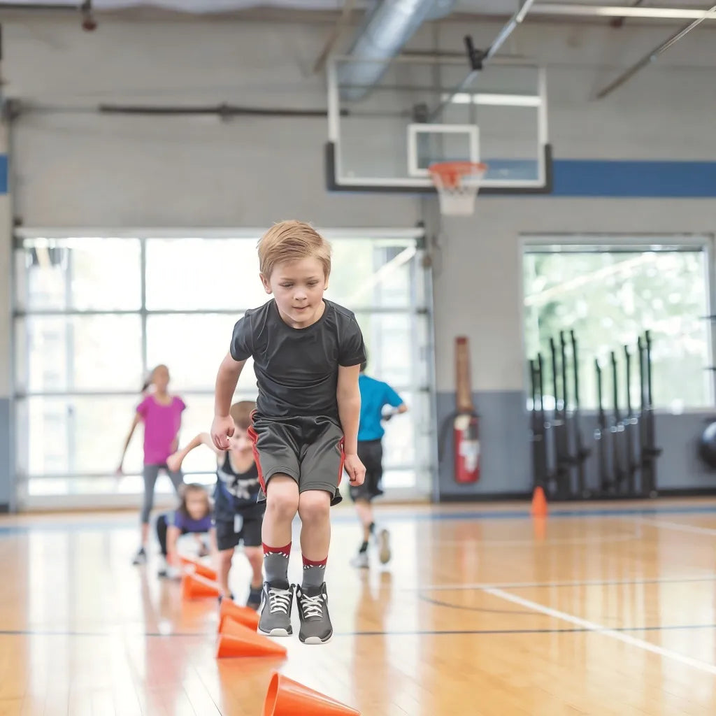A professional coach kneeling to guide a 3-year-old, demonstrating the personalized 1:6 coaching ratio.