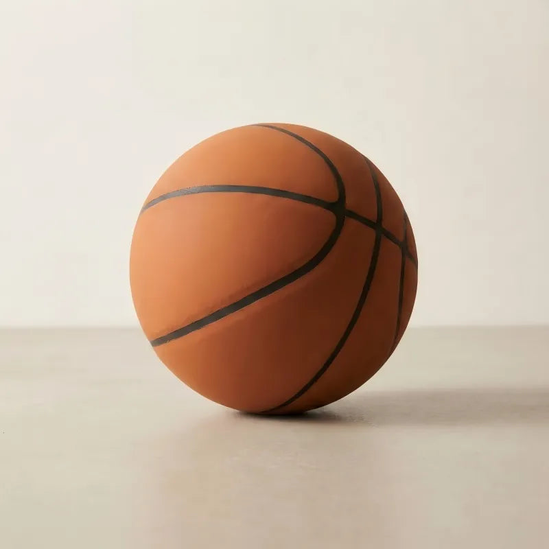 A premium matte orange silent basketball with signature high-density foam texture and deep molded grooves, isolated on a minimalist neutral studio background for a professional look.